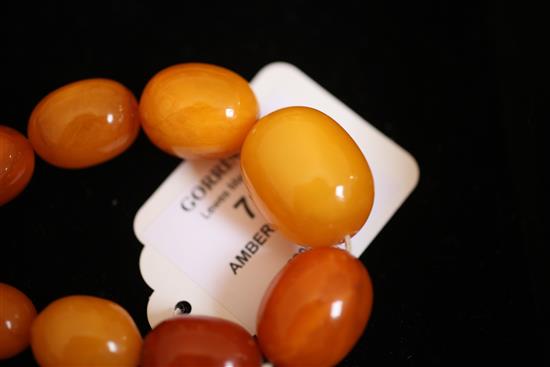 A single strand graduated oval amber bead necklace, 26in.